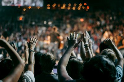 Large concert crowd of people with hands in the air