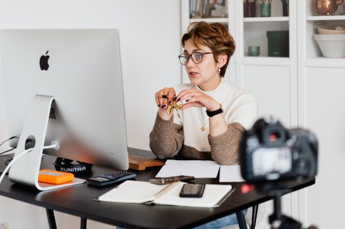 Woman live streaming a presentation at computer desk